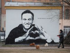 Женщина выгуливает собак перед граффити с изображением Алексея Навального в Санкт-Петербурге, Россия, 28 апреля 2021 года. Граффити гласит: "Герой нового времени". Фото: Антон Ваганов / Reuters. Фото: Давид Френкель/Коммерсант
